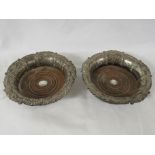 Pair of Georgian silver and fruitwood wine coasters with repousse work, the interiors inset with a