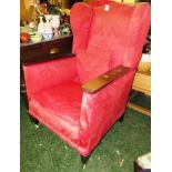 LOW WINGBACK ARMCHAIR WITH EXPOSED OAK ARMS IN PALE RED FLORAL PATTERED UPHOLSTERY