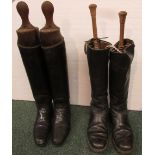 Two pairs of black leather riding boots with trees