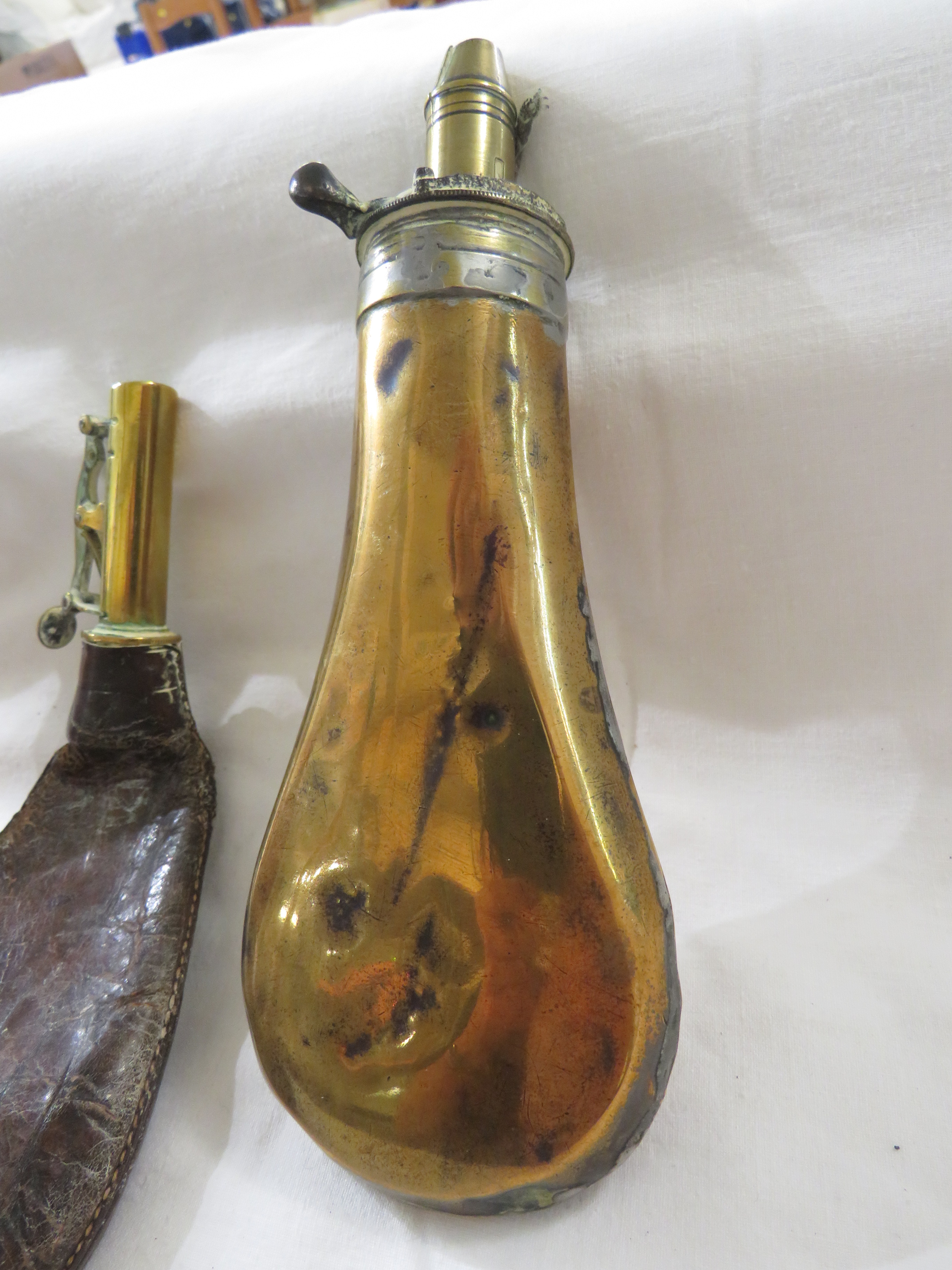 Three powder flasks - a plain brass example, one in copper embossed with pheasants and dog, the - Image 3 of 3