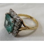 18ct gold ring set with an aquamarine (emerald cut 11.5mm x 10mm approximately) within a border of