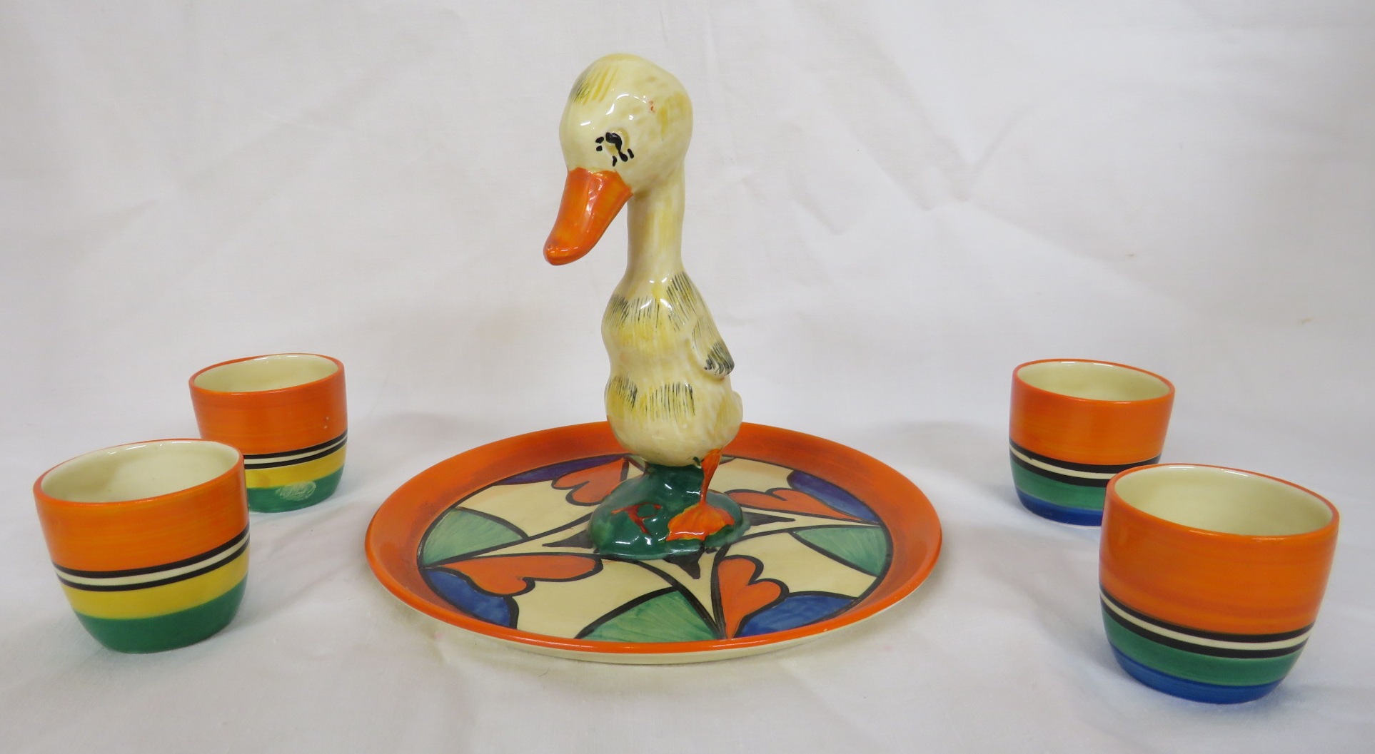 A Clarice Cliff Bizarre duck egg cruet, the stand with an orange border and stylized leaf pattern in