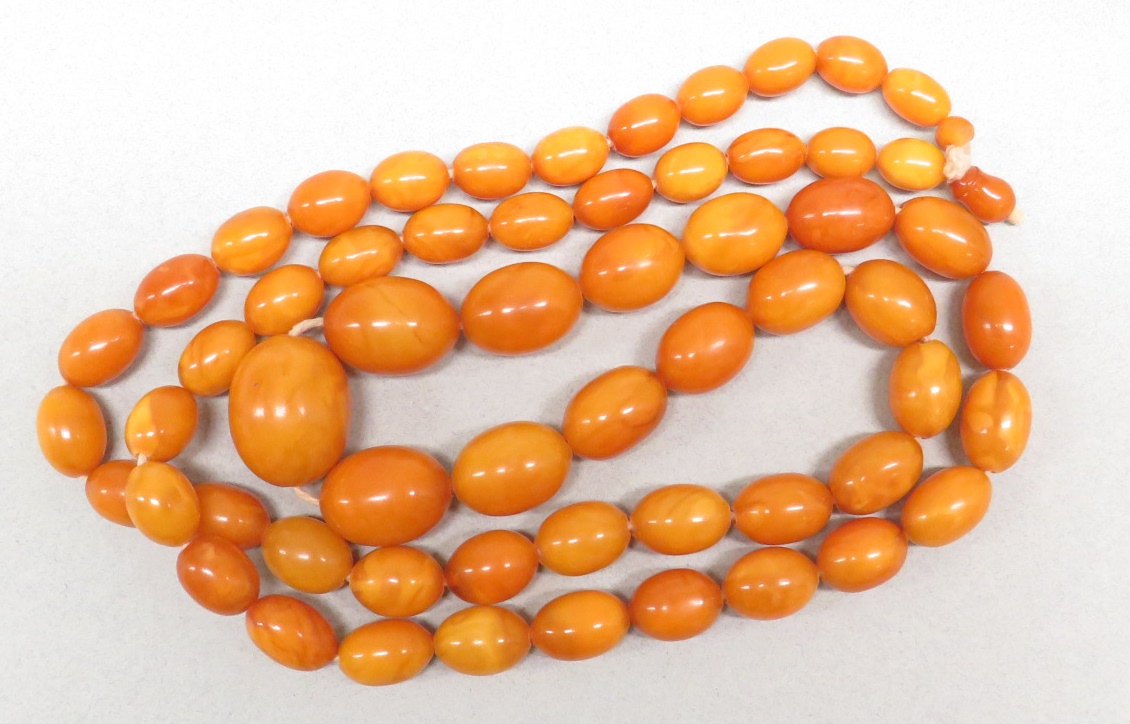 A necklace of graduated amber beads, length about 112cm, the largest bead approximately 3cm long