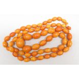 A necklace of graduated amber beads, length about 112cm, the largest bead approximately 3cm long