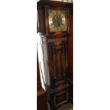 An early 20th century chiming oak long case clock with a square hood, carved roundel frieze and