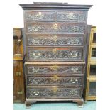 19th century oak chest on chest, the drawer fronts with broad foliate scrolled carving, brass