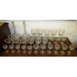 A suite of drinking glasses and a near pair of bottle shape decanters, all etched with key fret