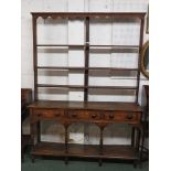 A George III oak open back dresser, the upper section with a wavy frieze with mug hooks, three plate