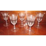 Five 19th century wine glasses with bell-shape bowls etched with a band of flowers and leaves, the