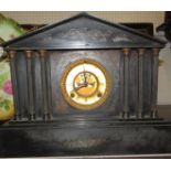 A Victorian Palladian style black slate chiming mantel clock flanked with three reeded Doric columns