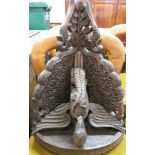 A corner shelf bracket heavily carved with a bird with open wings and a lizard. The shelf has a