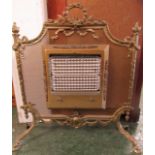 A vintage electric fire in a brass mesh frame standing on four hoof feet with acanthus mouldings,