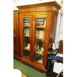 A French fruit wood bevel glazed store cupboard of three shelves. The pediment has a tongue and dart