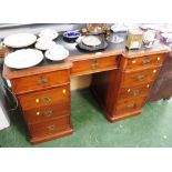 STAINED PINE PEDESTAL DESK WITH NINE DRAWERS, BRASS HANDLES AND BLACK LEATHER SCRIBER