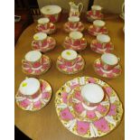 PINK AND GILT GLAZED TEA SERVICE INCLUDING CUPS, SAUCERS AND CAKE PLATES ETC