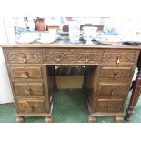 OAK NINE DRAWER PEDESTAL DESK WITH BRASS DROPLET HANDLES, CARVED DRAWER FRONTS TO TOP AND GREEN