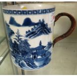 POTTERY MUG WITH RATTAN CLAD HANDLE DECORATED IN UNDERGLAZE BLUE WITH CHINESE LANDSCAPE