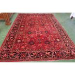 A Baluchi styled rug of three joined blue medallions on a red ground with central reservation within