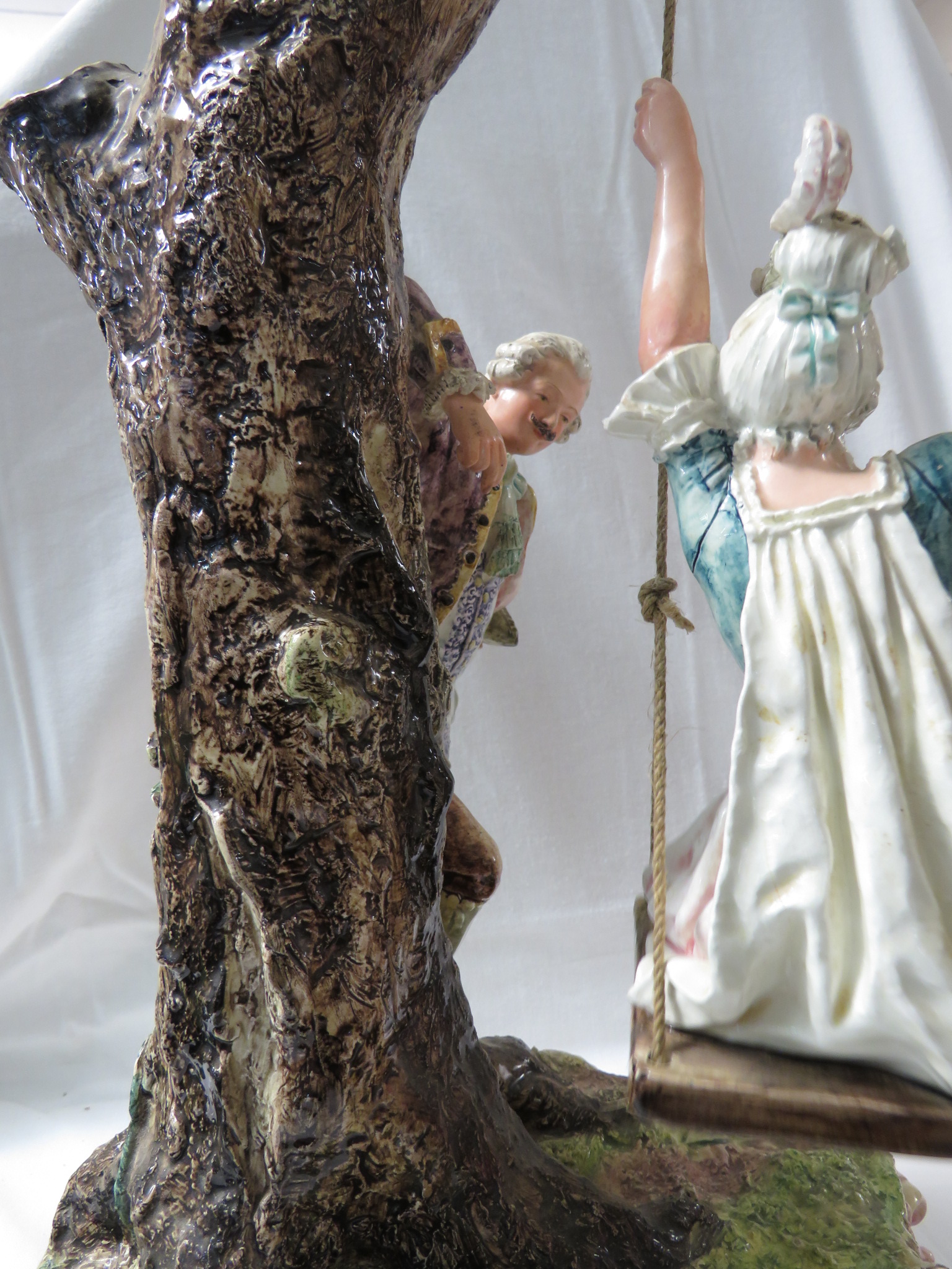 A large polychrome glazed pottery model of a lady in a swing seat suspended from a tree with - Image 4 of 5