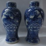 A pair of Chinese porcelain baluster vases hand painted in underglaze blue with scrolled foliage and