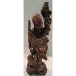 A carved wooden figural table lamp, Chinese wise man with scroll and crane, height including light