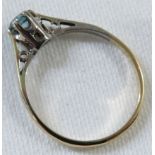 A dress ring set with an aquamarine (diameter 3.5mm), the shank stamped 9ct and toned white