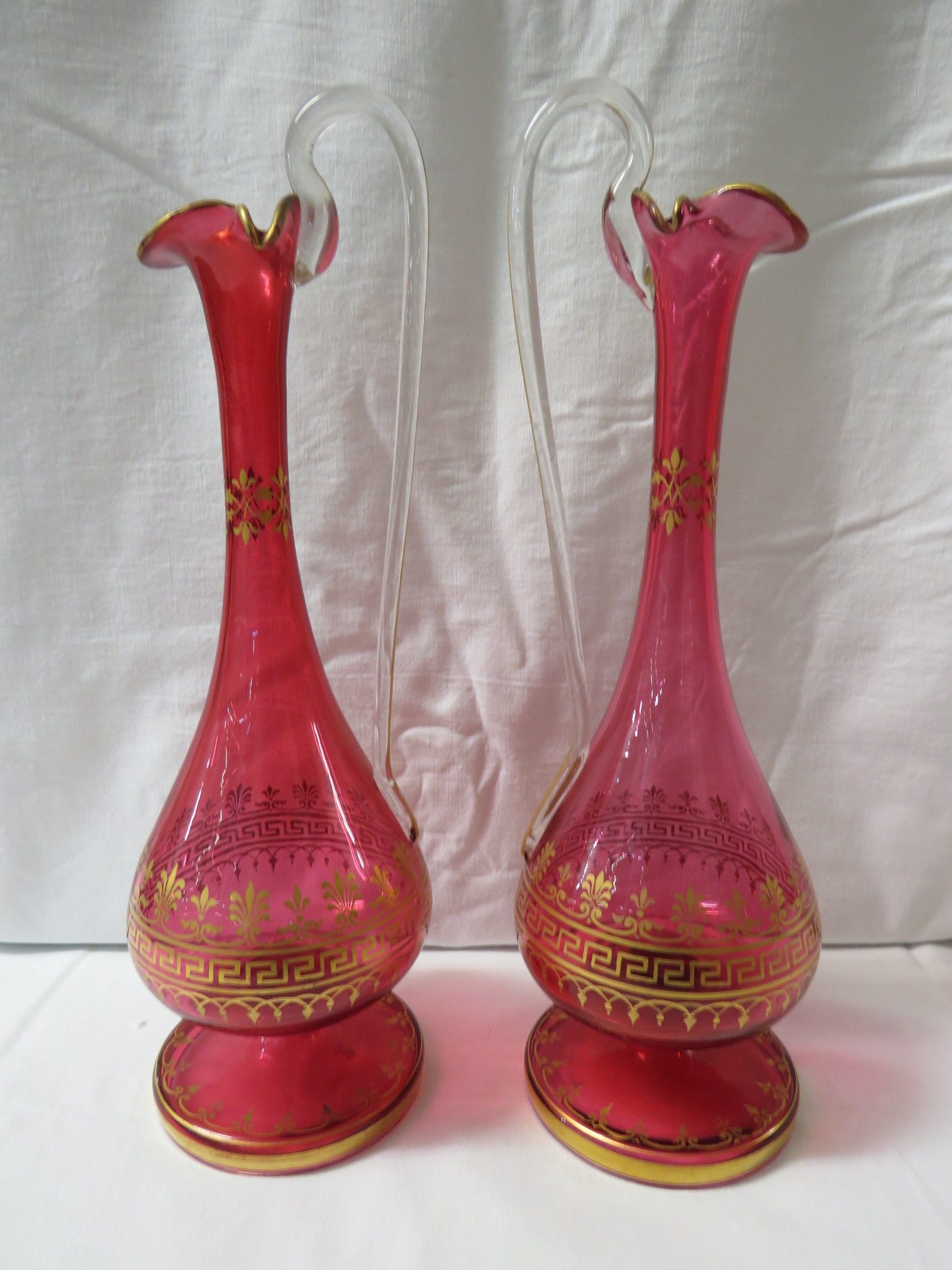 A pair of Victorian long stemmed cranberry glass ewers with key fret gilding, height 27cm - Image 2 of 10