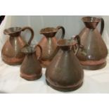 A matched set of five copper measures, marked 4 gallons, two gallons, 2 gallons (two examples),