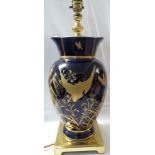 A cobalt blue and gilt vase converted to a table lamp with pleated and tasseled shade, the vase in