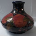 Moorcroft pottery pomegranate vase of squat form, dark blue ground, the base stamped MOORCROFT