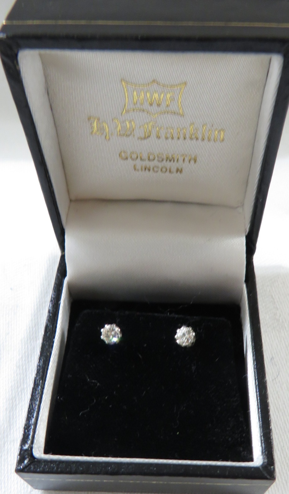 A pair of solitaire diamond ear studs, brilliant cut, each stone estimated at 0.2 carat, white metal