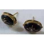 Pair of black onyx oval earrings set with seed pearl in star setting, yellow metal mounts with