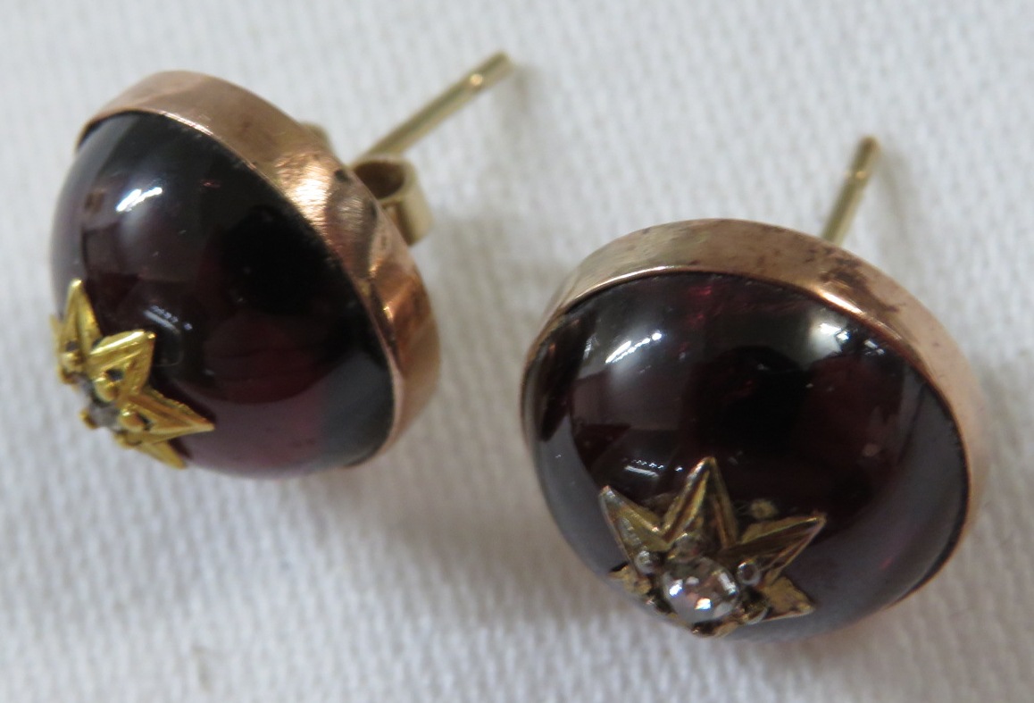 A pair of domed red glass earrings to resemble amber, each set with a small diamond in a star shaped