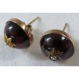 A pair of domed red glass earrings to resemble amber, each set with a small diamond in a star shaped