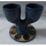 Troika pottery double egg cup, blue glaze, the circular foot in fawn with painted brown discs, the