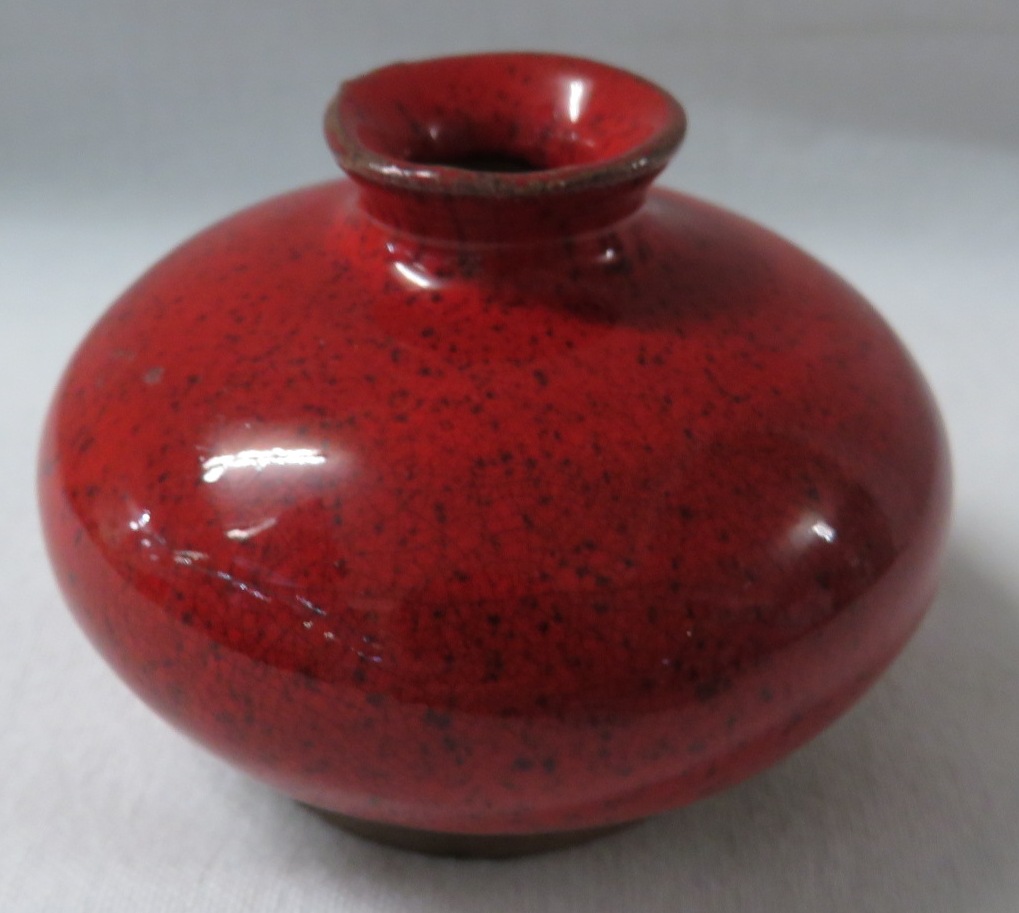 A Ming style terracotta vase or pot of squat form in a bright red mottled glaze falling short of the