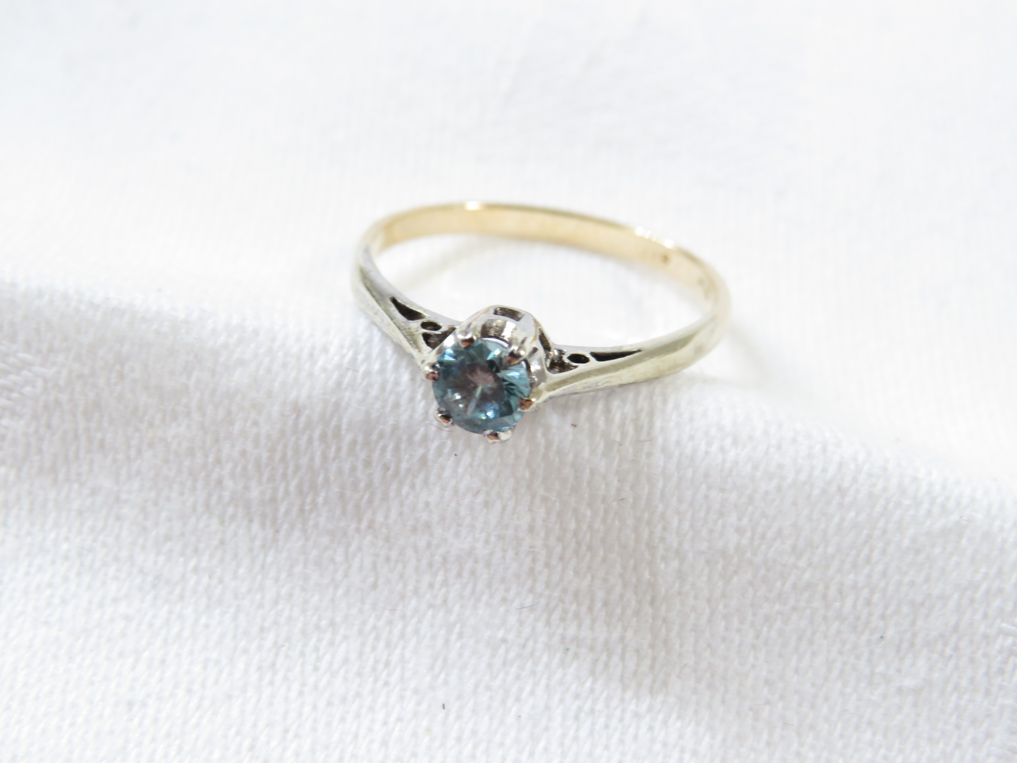 A dress ring set with an aquamarine (diameter 3.5mm), the shank stamped 9ct and toned white - Image 3 of 3