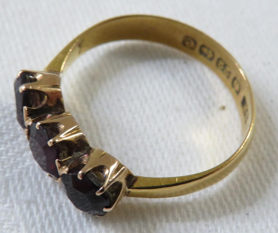 22ct gold ring set with three garnets, British assay marks, total weight of ring 3.2g, size P for