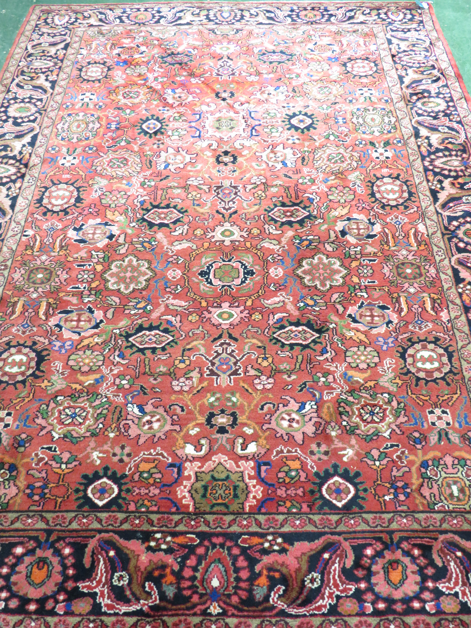 An Iranian carpet with three floral margins, a central reservation with single medallion and