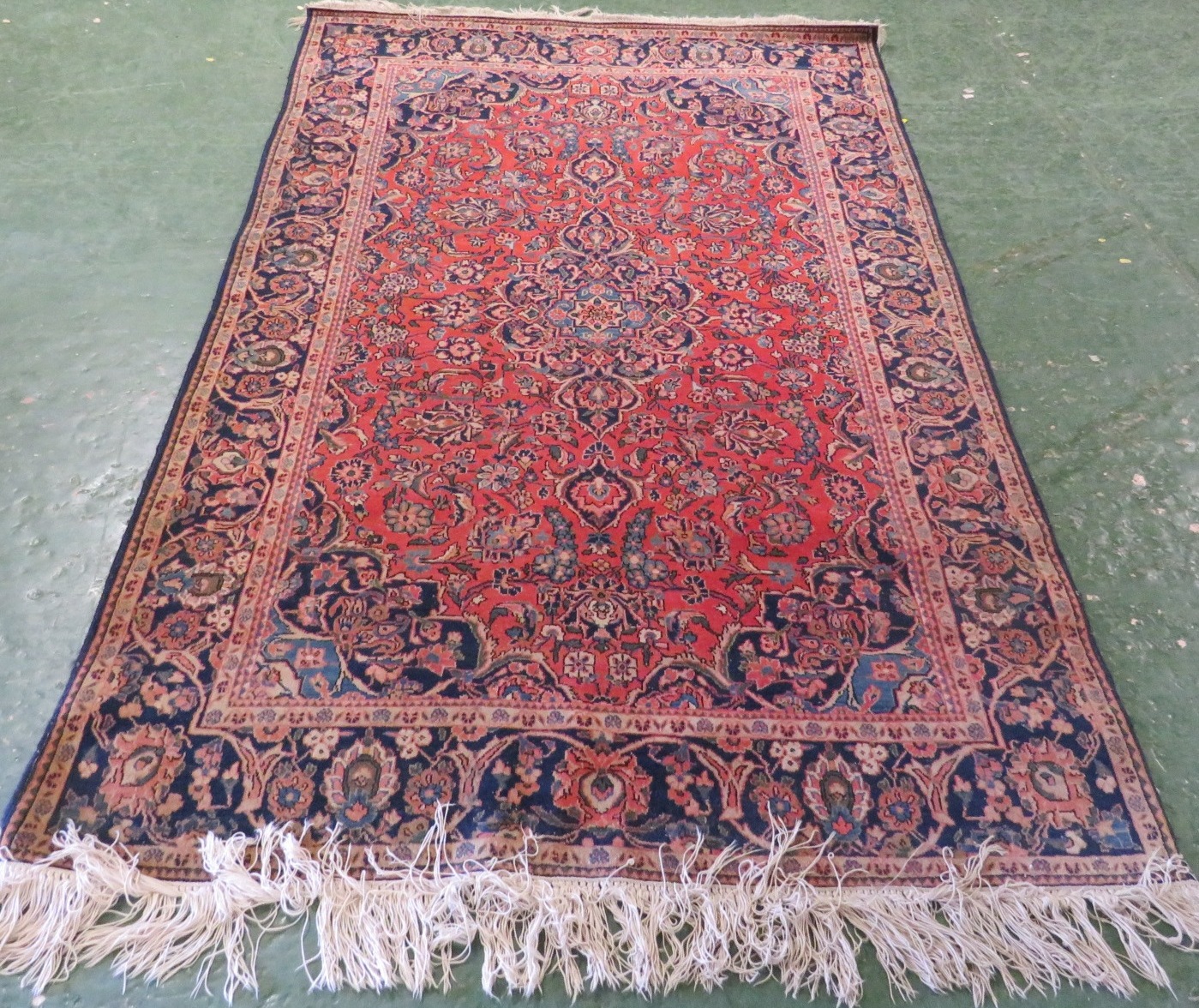 A 20th century fringed Tehran rug with single blue ground margin and a central red ground reserve