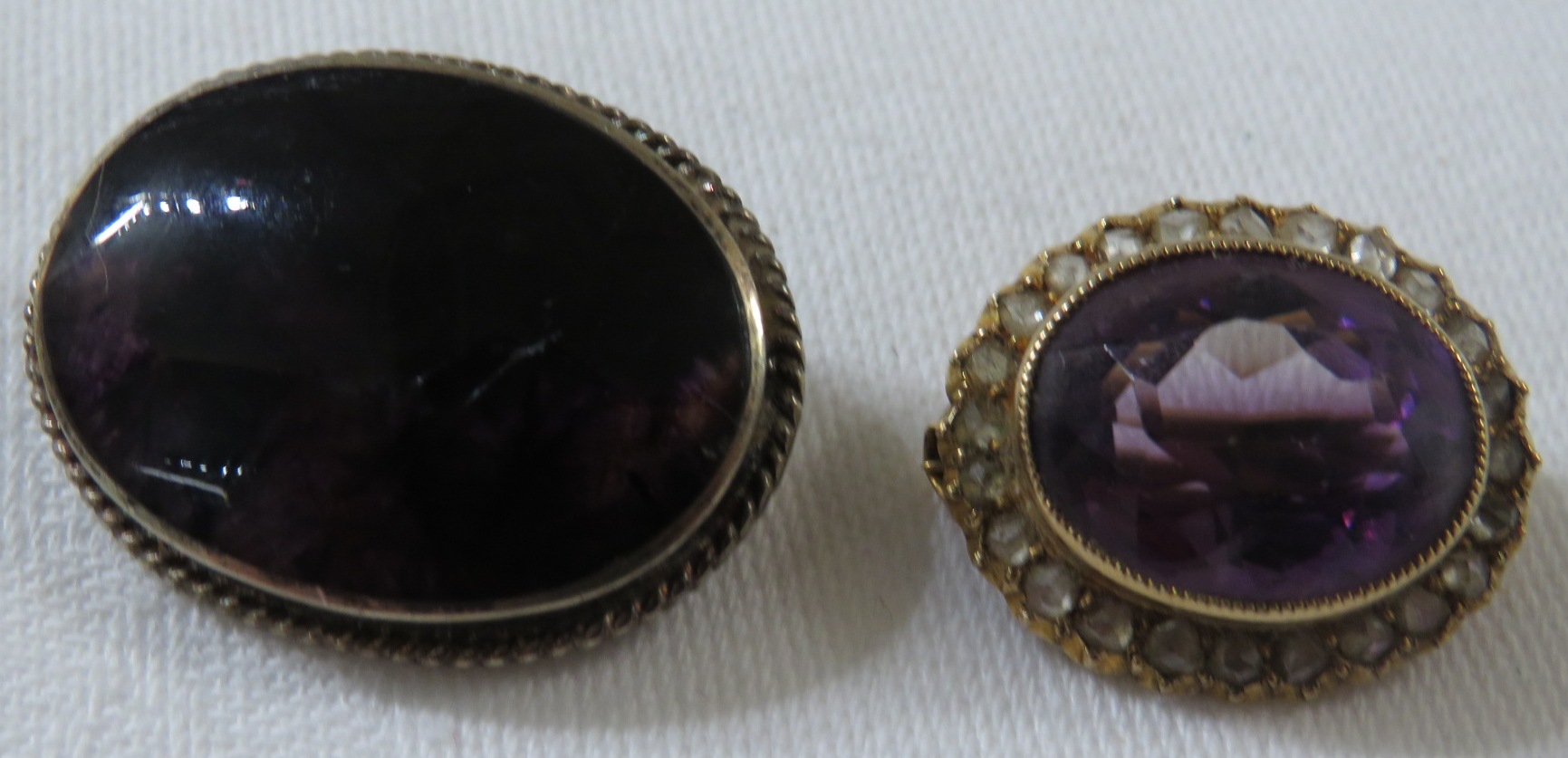 Two brooches - an oval amethyst brooch set within a halo of chip diamonds (overall 20mm x 16mm), and