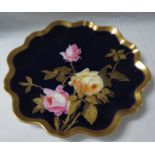 A porcelain plate with wavy edge and gilt rim, cobalt blue ground and painted and gilded with pink
