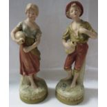 Pair of Royal Dux pottery water carrier figures, male and female, in pink and green with gilding, on