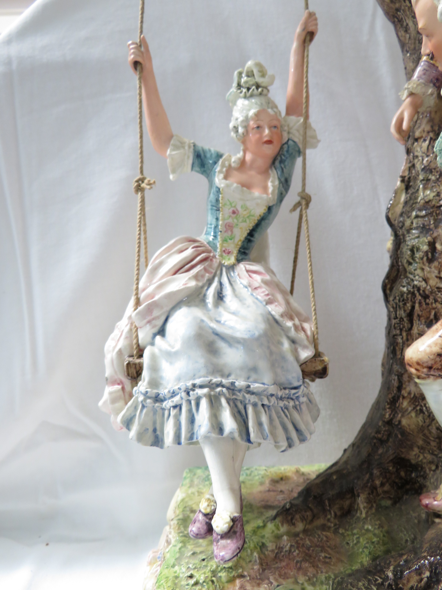 A large polychrome glazed pottery model of a lady in a swing seat suspended from a tree with - Image 2 of 5