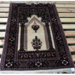 A modern red and cream ground machine woven prayer rug with motif of lamp and vase (112cm x 76cm)
