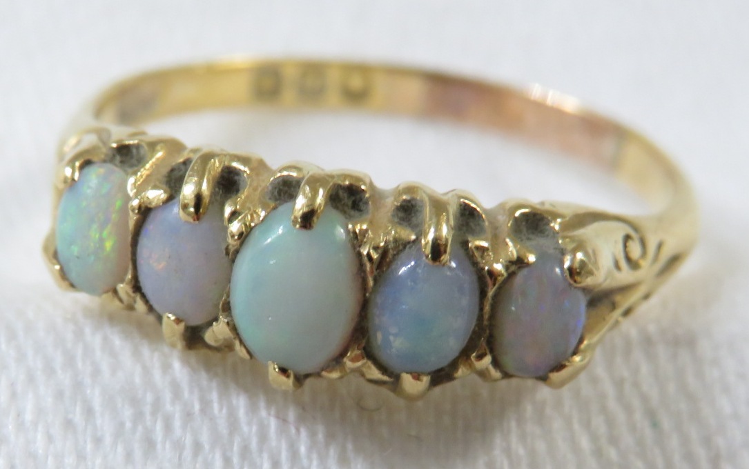 18ct gold ring set with a row of five opals (the largest 4mm x 3mm), British hallmarks, 3.3g, size S