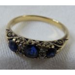 A ring set with three graduated sapphires spaced with two pairs of small diamonds, the largest