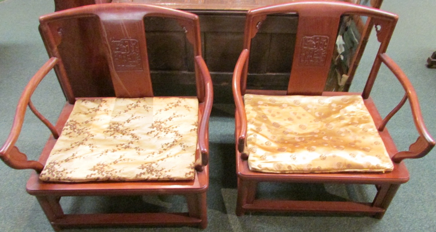 A pair of redwood mandarin armchairs, the central splat carved with a square panel of two stylized