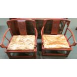 A pair of redwood mandarin armchairs, the central splat carved with a square panel of two stylized
