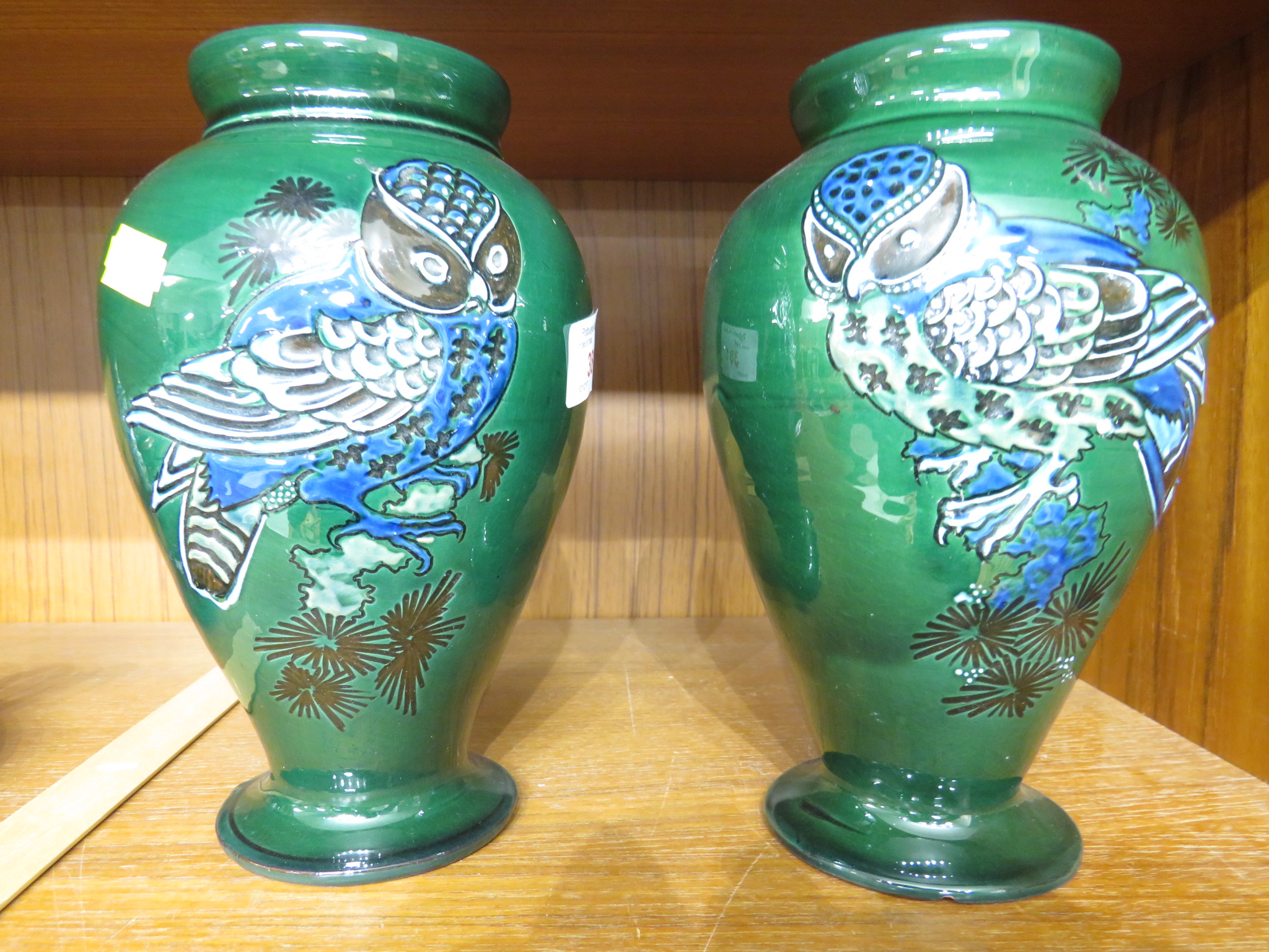 PAIR OF C H BRANNAM BARUM POTTERY VASES, GREEN GROUND DECORATED WITH OWLS, HEIGHT 20CM (A/F)
